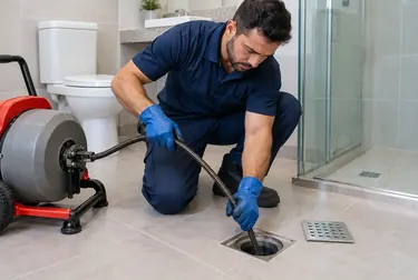 Profissional realizando desentupimento de ralo em ambiente residencial em Patos/PB.